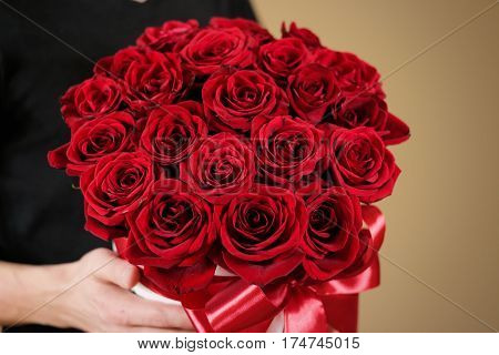 Man In Black T Shirt Holding In Hand Rich Gift Bouquet Of 21 Red Roses. Composition Of Flowers In A