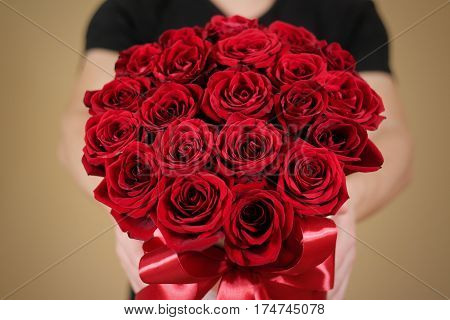 Man In Black T Shirt Holding In Hand Rich Gift Bouquet Of 21 Red Roses. Composition Of Flowers In A