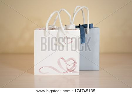 Blank Two Paper Gift Bag Mock Up Standing On A Wooden Table. Empty Plastic Package Mockup Stand On T