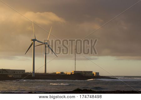 Pair of wind turbines move at sunset beautiful light, Spain, Fuerteventura island