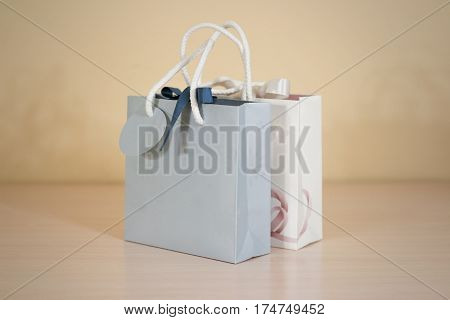 Blank Two Paper Gift Bag Mock Up Standing On A Wooden Table. Empty Plastic Package Mockup Stand On T