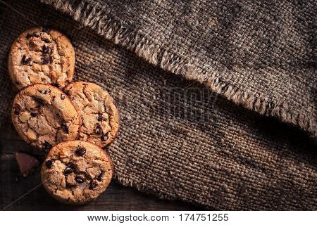 Chocolate cookies on dark napkin on wooden table. Chocolate chip cookies on brown coffee color cloth macro top view