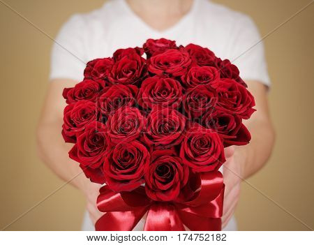 Man In White T Shirt Holding In Hand Rich Gift Bouquet Of 21 Red Roses. Composition Of Flowers In A