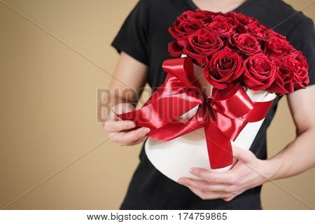 Man In Black T Shirt Holding In Hand Rich Gift Bouquet Of 21 Red Roses. Composition Of Flowers In A