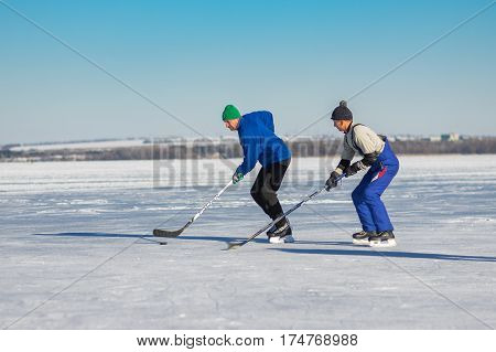 DNEPR UKRAINE - JANUARY 22, 2017: Amateur men playing hockey on a frozen river Dnepr in Dnepr city, Ukraine at January 22, 2017