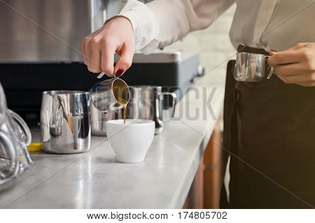 famale barista is preparing coffee on coffee machine