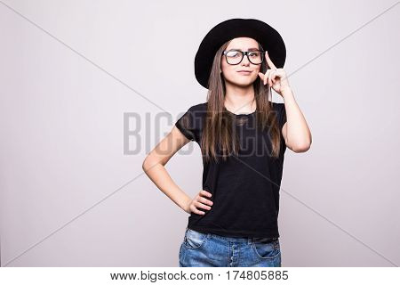 Young girl doing emotion. Dressed in a black shirt, black hat, glasses.
