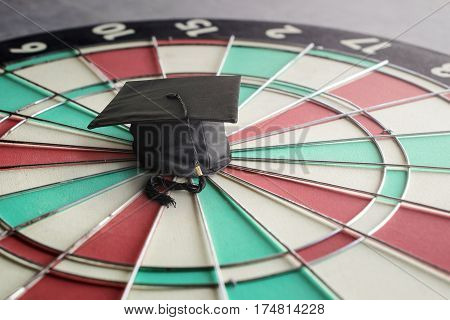 congratulations graduates cap on dartboard education target concept.