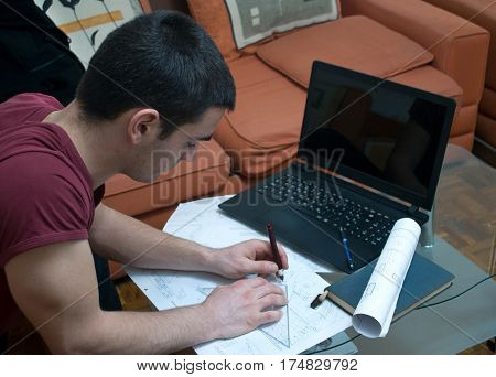 Photographing Danila Mazić in a tight red shirt and black pants while drawing construction plans, Novi Sad, Serbia