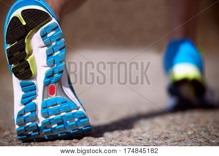 Foot closeup athlete running in sneakers outdoors.