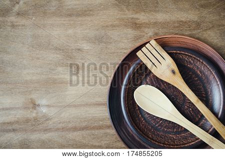 Rustic Kitchen Utensils: the Ceramic Plates and Wooden Cutlery on Wooden Background. Home Wares. Kitchen Decor in Rustic Style. View From Above With Copy Space.