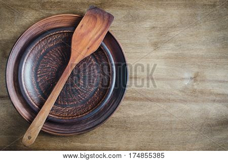 Rustic Kitchen Utensils: the Ceramic Plates and Wooden Cutlery on Wooden Background. Home Wares. Kitchen Decor in Rustic Style. View From Above With Copy Space.