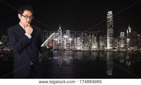 Double Exposure Confident Asian Businessman Reading Notebook Or Document File With Cityscape On Blur