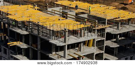 Construction workers installing mounting horizontal formwork on the building construction site.