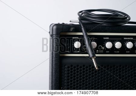 Close up of Black guitar amplifier with jack cable on white background.