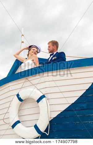 Wedding couple on small boat. The bride and groom on the ship.