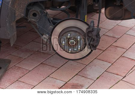 Disk brake on a car here Mechanic at the car brake repair in a car service workshop