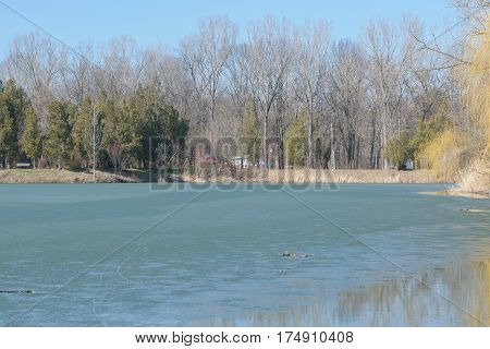 Frozen lake in spring time at Memorial Park Constantin Stere in Bucov near Ploiesti Romania