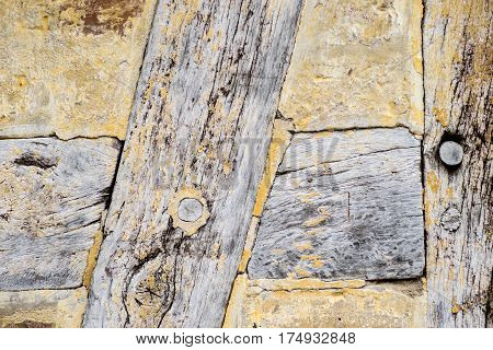 Detail of Old cracked oak timber in a timber-framed building. Oak wood structure with wattle and daub infill. Painted with yellow whitewash