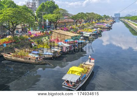 Ho Chi Minh City, Vietnam - January 26th, 2017: Boating along canal with apricot carry flowers, confetti, almond tree spring to sell everyone distillation welcome Tet in Ho Chi Minh City, Vietnam