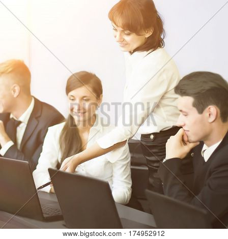 business, technology and office concept - smiling business team sitting at laptops