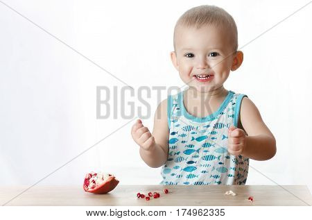 Baby eats a pomegranate ripe and juicy very tasty and joyfully