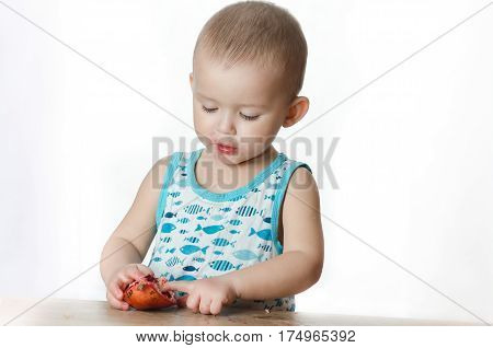 Baby eats a pomegranate ripe and juicy very tasty and joyfully