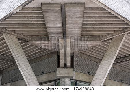 Frontal view of a robust concrete building in the city. Constructed during the brutalism momevent. A stark style of functionalist architecture especially of the 1950s and 1960s characterized by the use of steel and concrete in massive blocks.