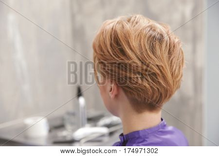 Young woman with trendy hairstyle at beauty salon