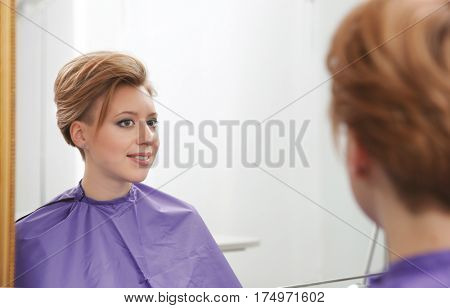 Young woman with trendy hairstyle at beauty salon