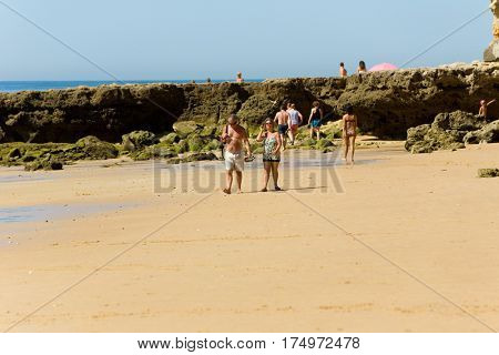 ALBUFEIRA, PORTUGAL - AUGUST 21, 2016: People at the famous beach of Olhos de Agua in Albufeira. This beach is a part of famous tourist region of Algarve.