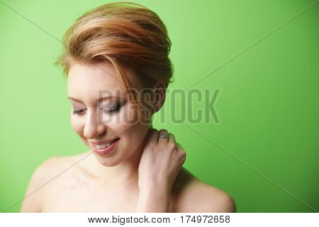 Young woman with trendy hairstyle on green background