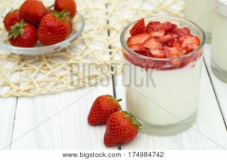 Strawberry yogurt on the white wooden background. Healthy diet