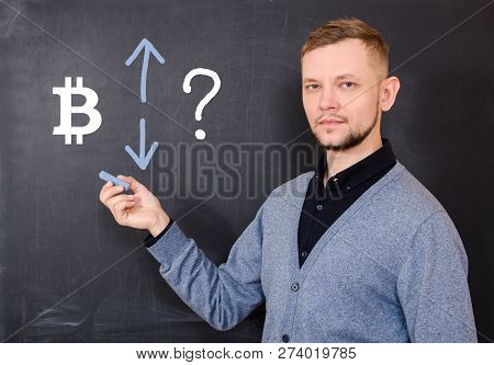Man At Black Board On Which Bitcoin Sign Is Drawn, The Up And Down Arrows And The Question Mark, Ana