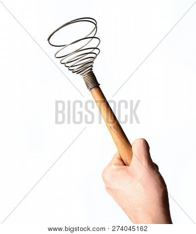 A Man's Hand Holds A Whisk Isolated On White Background. Kitchen Tools For Cooking.