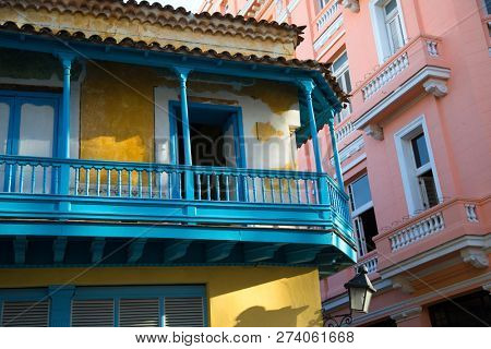 Colorful architecture in Havana Cuba.  Yellow and blue building with a coral building in background