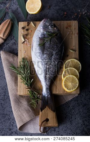 Mediterranean Seafood Concept. Raw Dorado Fish With Olive Oil, Lemon, Rosemary On Stone Table. Fresh