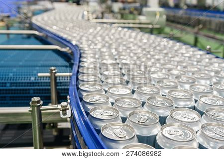 Conveyor Line Carrying Thousands Aluminum Beverage Cans At Factory. Concept Of Industrial Growth.