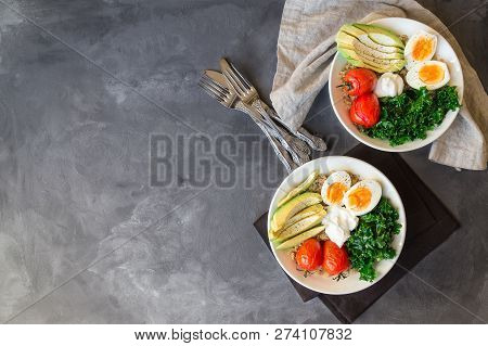 Quinoa Buddha Bowls With Baked Tomatoes, Avocado, Kale, Boiled Eggs And Greek Yogurt On Gray Concret