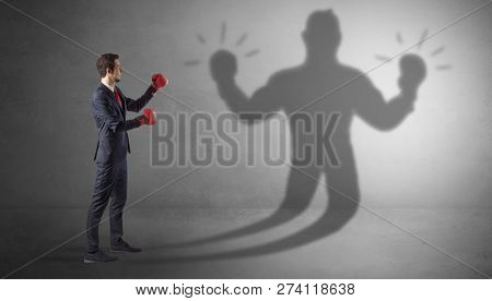 Businessman trying to fight with his unarmed shadow