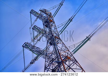 A Transmission Tower Or Electricity Pylon With Blue Sky. It Is A Tall Structure, Usually A Steel Lat