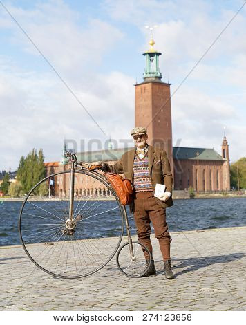 Stockholm - Sept 22, 2018: Senior Man Wearing Old Fashioned Tweed Suit Holding A High Wheeler Bicycl