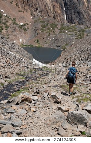 Female Hiker Walks Along The Trail Of Rocky Scree And Talus Along The 20 Lakes Basin Area Of Califor