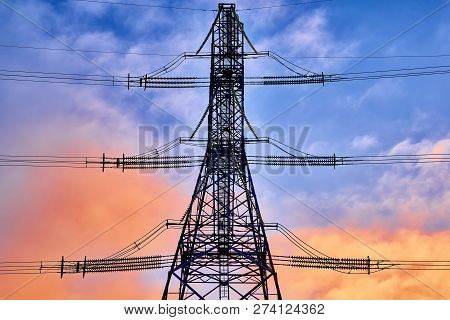 A Transmission Tower Or Electricity Pylon With Blue Sky. It Is A Tall Structure, Usually A Steel Lat