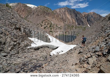 Female Millennial Hiker Stops To Use Her Smart Phone While On A Nature Hike Through The Mountains, N