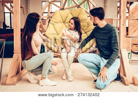 Young Family With Daughter In Furniture Store. Unny Day. Good Mood. Loving Each Other. Bright Light.
