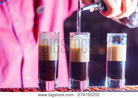 preparation of a shot cocktail b-52 at the bar. close-up
