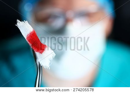 Surgeon In Sterile Uniform Arms Holding And Passing To Colleague Tools With Bio Material Wad Closeup