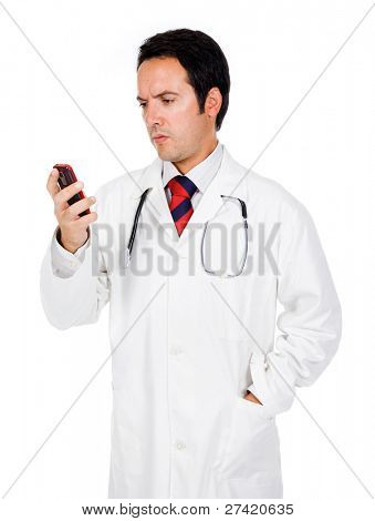 Mladý doktor přečtení zpráv na telefonu a dívá ustaraně