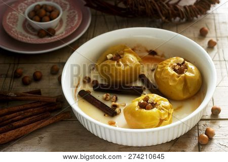 Baked Apples With Raisins, Hazelnuts And Cinnamon On Wooden Background. Rustic Style.